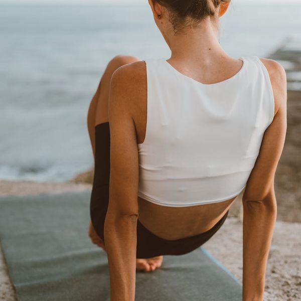 Person feeling energized and stretching outdoors during sunrise.